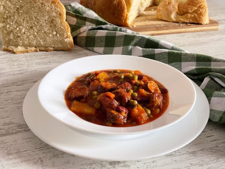 serving 1 Delicious Peas and Vegetable Stew with Smoked Sausages in Fiery Red Tomato Sauce