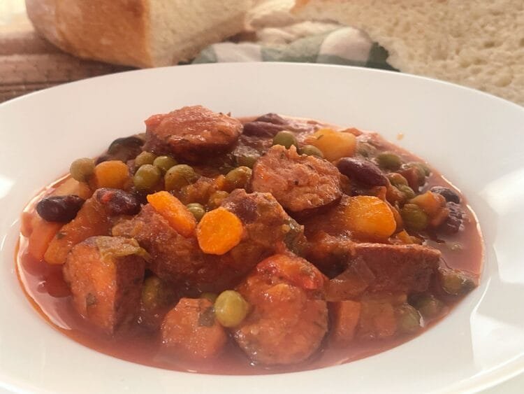 serving 2 Delicious Peas and Vegetable Stew with Smoked Sausages in Fiery Red Tomato Sauce
