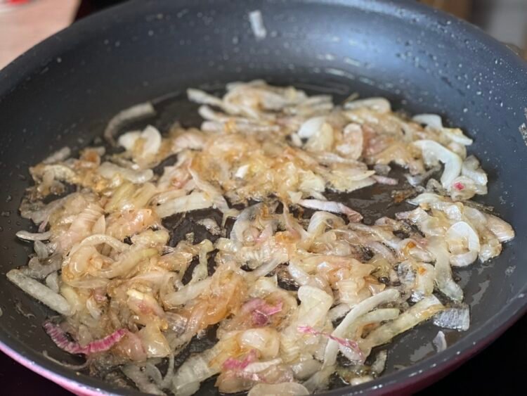 ceapa-caramelizata-in-tigaie Ceapă tăiată fâșii subțiri, caramelizată în tigaie până capătă o culoare aurie și o textură moale