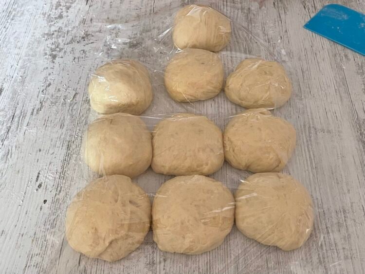 aluat-chifle-odihna Porții de aluat așezate pe blat și acoperite, lăsate la odihnă înainte de modelare pentru chifle pufoase de hot dog