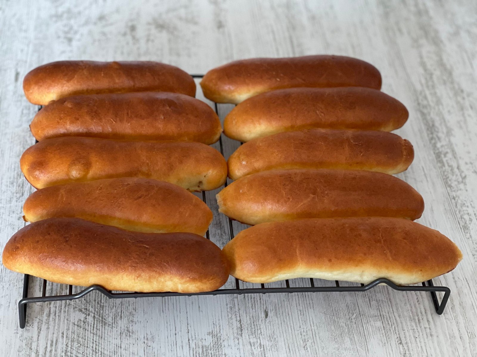 Chifle de hot dog așezate pe grătar de răcire, după coacere, lăsate să respire pentru a evita condensul
