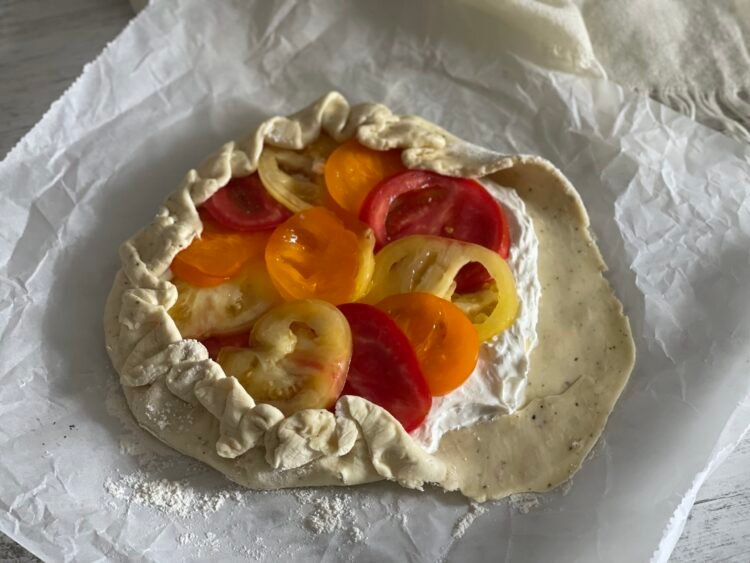 galette-impachetare-margini Aluatul galettei cu marginile ridicate și pliate manual peste umplutură, într-un stil rustic, înainte de decorare.